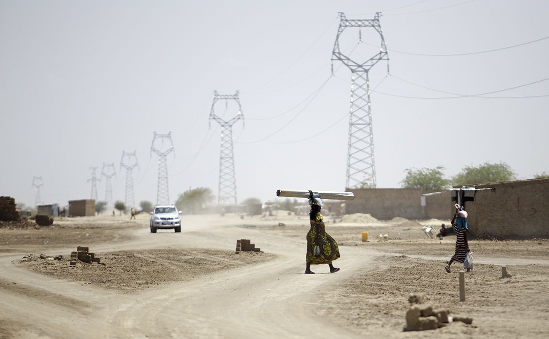Dos mujeres cruzan un camino delante de un tendido eléctrico cerca de Yamena, la capital del país / Getty Images